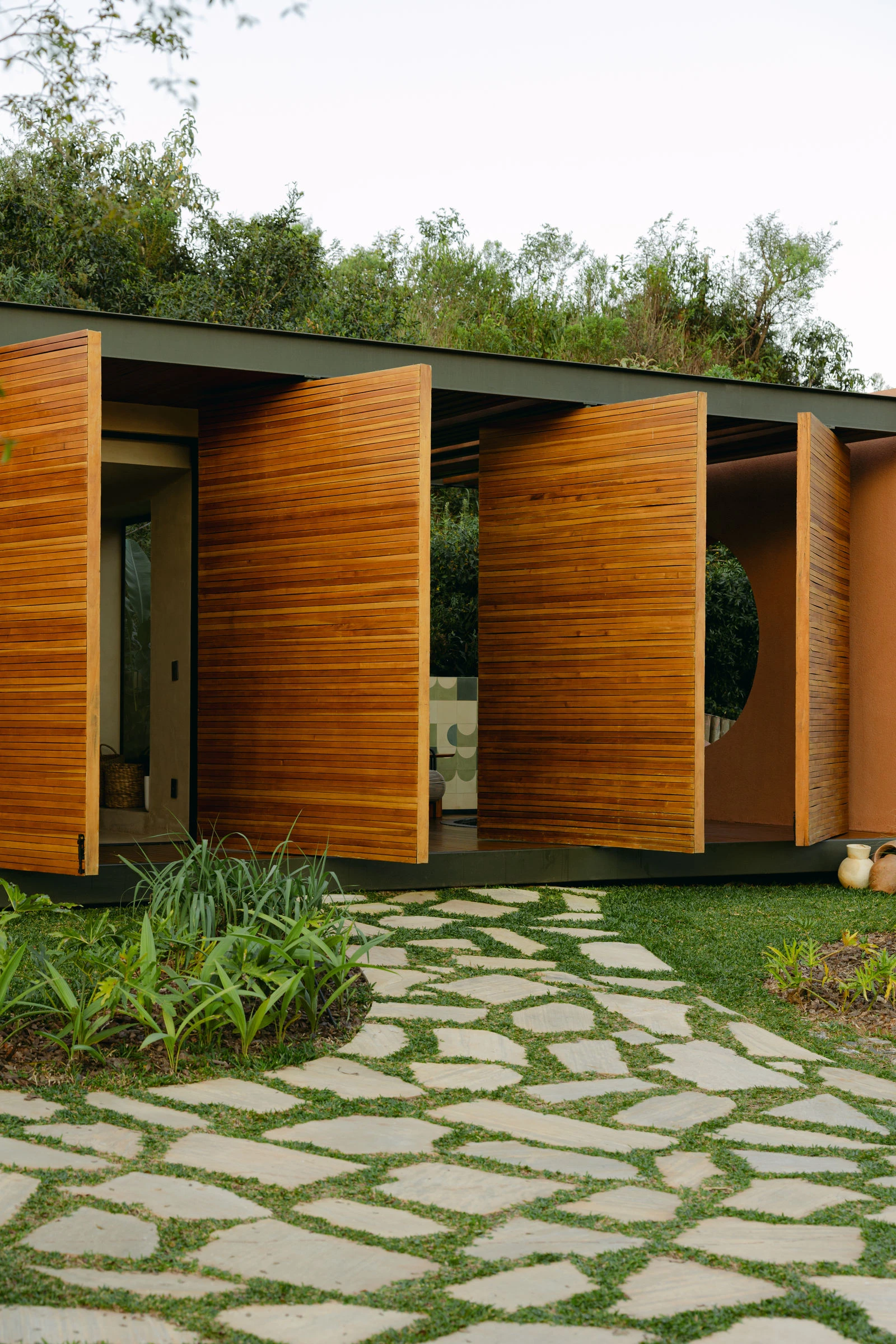 Fachada do spa com painéis pivotantes de madeira