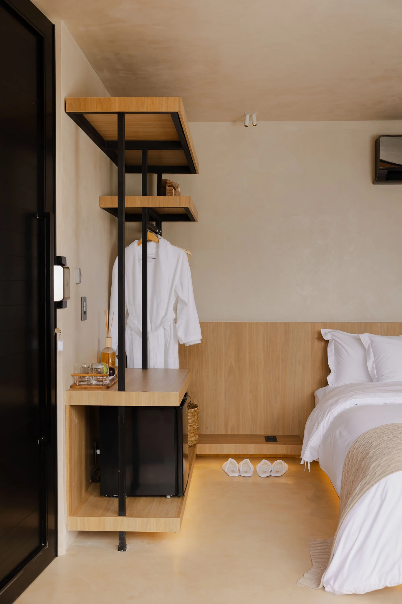 Closet aberto da Suíte com Vista para a Montanha, com roupões, frigobar e a cama ao lado