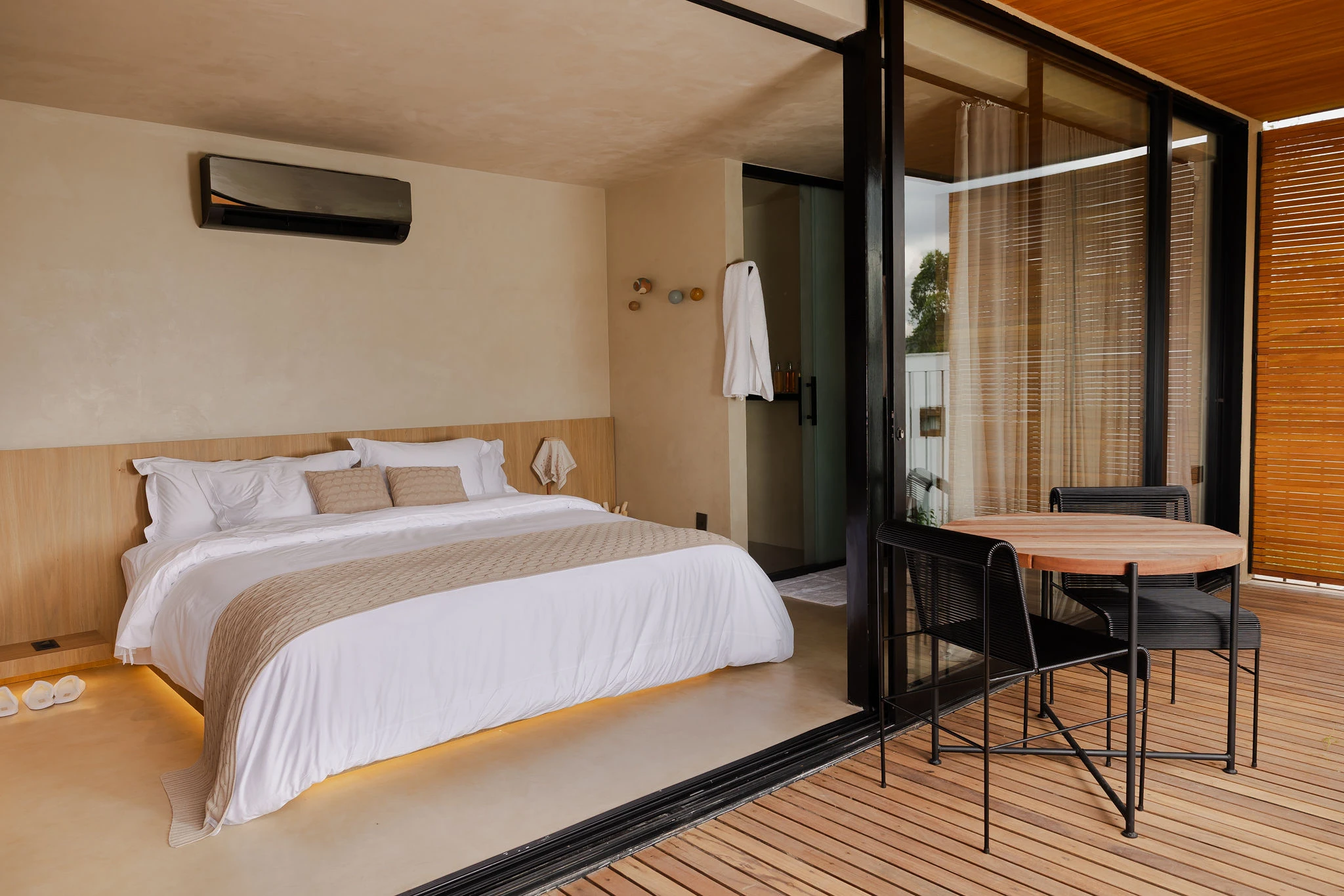 Quarto da Suíte com Vista para a Montanha, com cama king e porta de correr aberta para o deck