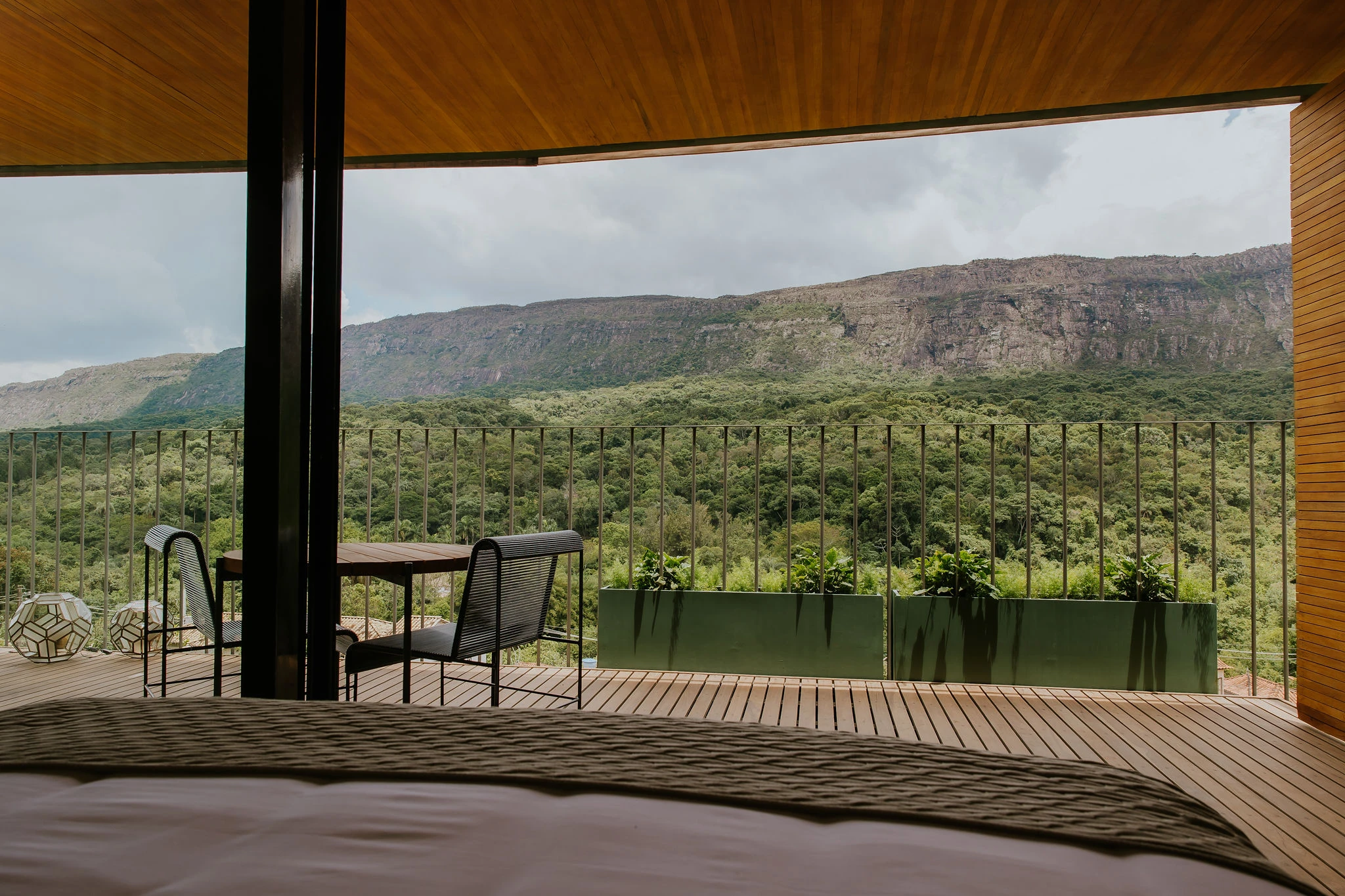 Varanda da Suíte com Vista para a Montanha, com deck de madeira e a Serra de São José à frente